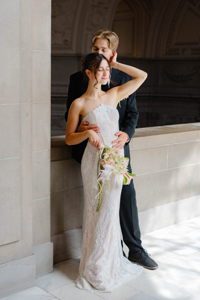 Bride with her hand on grooms face on Mayor's Balcony
